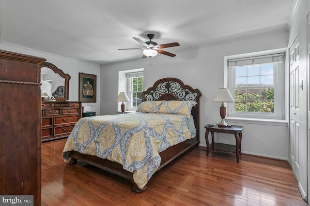 bedroom with wood-type flooring, crown molding, baseboards, and ceiling fan
