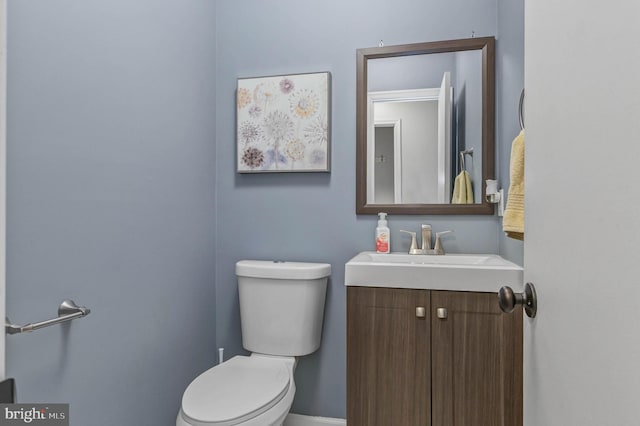 bathroom with vanity, toilet, and baseboards