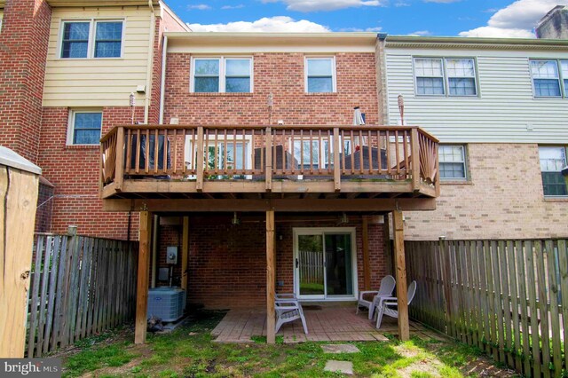 back of house featuring central AC, a fenced backyard, and brick siding