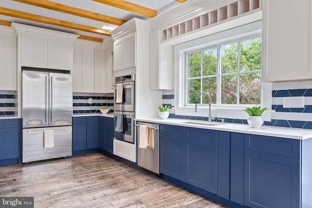 kitchen featuring stainless steel appliances, blue cabinets, and a sink