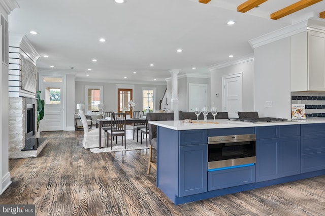 kitchen with stainless steel appliances, light countertops, blue cabinets, and dark wood-type flooring