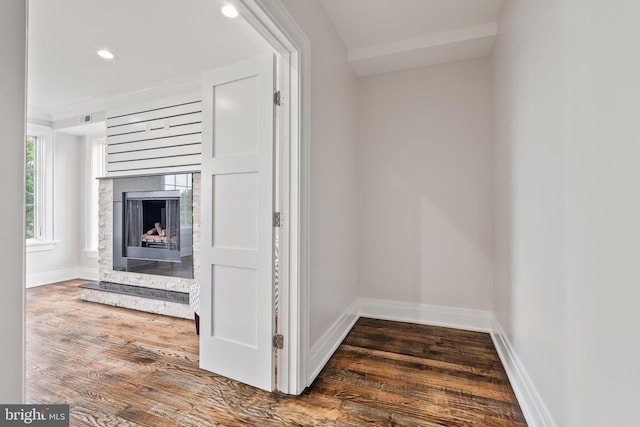 interior space featuring recessed lighting, a fireplace, baseboards, and wood finished floors