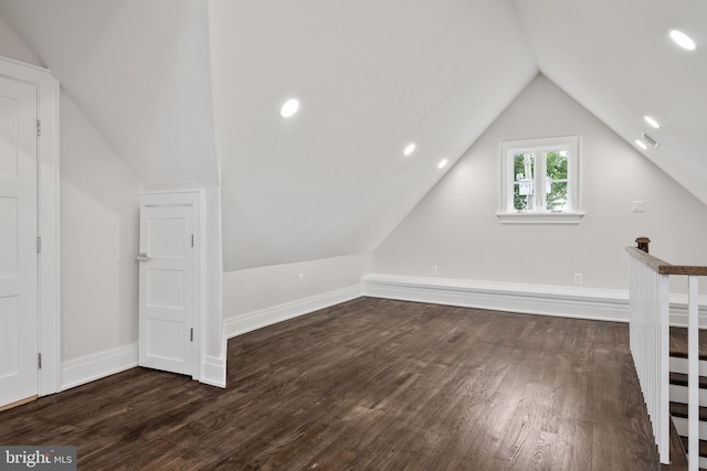 bonus room with baseboards, visible vents, vaulted ceiling, and dark wood-type flooring