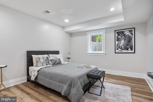 bedroom with baseboards, visible vents, wood finished floors, and recessed lighting