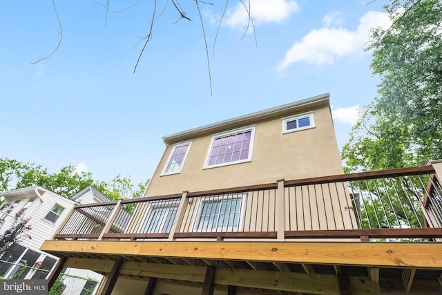 back of property with a wooden deck and stucco siding