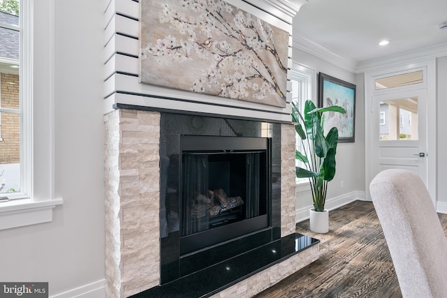 interior details with recessed lighting, a fireplace, wood finished floors, baseboards, and crown molding