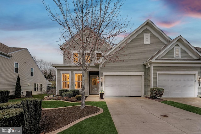 traditional-style home featuring concrete driveway, cooling unit, and an attached garage