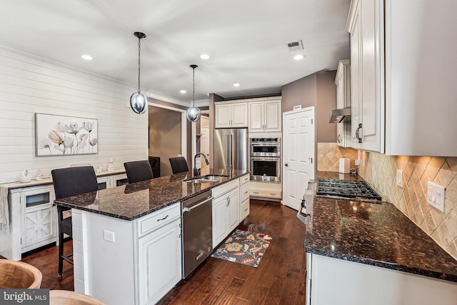 kitchen with visible vents, dark wood-type flooring, a sink, tasteful backsplash, and appliances with stainless steel finishes