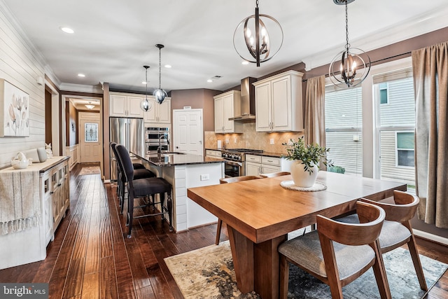 dining area featuring dark wood finished floors, recessed lighting, ornamental molding, wood walls, and a notable chandelier