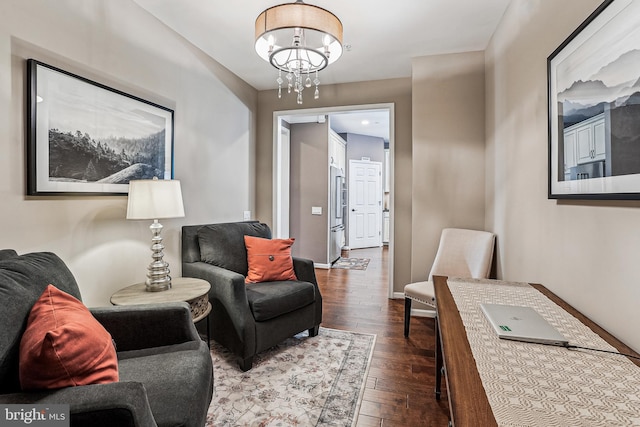 living room with a notable chandelier, baseboards, and dark wood-style flooring