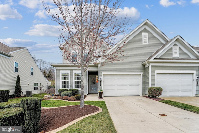 traditional-style house with central air condition unit, driveway, and an attached garage