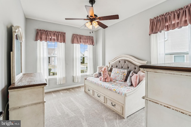 bedroom featuring baseboards, light colored carpet, and a ceiling fan