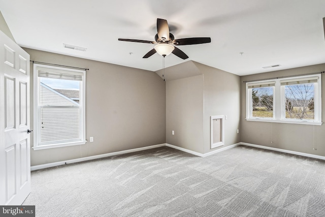 carpeted empty room with baseboards, visible vents, and a wealth of natural light