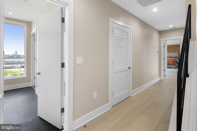 hallway featuring recessed lighting, visible vents, baseboards, and light wood-style flooring