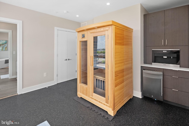 kitchen featuring baseboards, a sauna, recessed lighting, light countertops, and dark brown cabinets