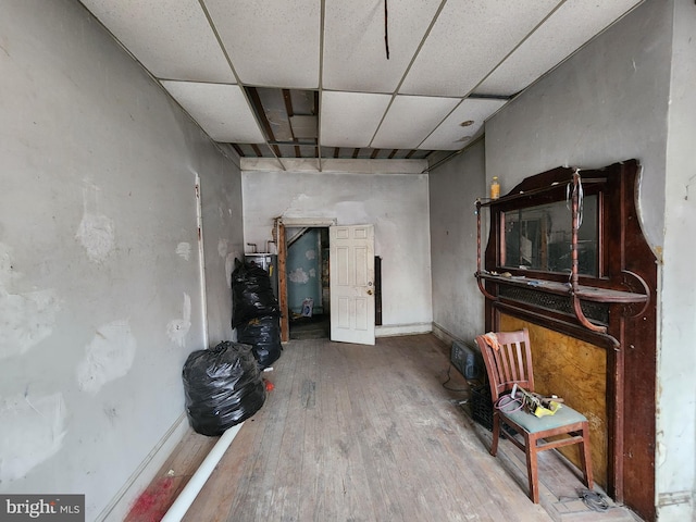 miscellaneous room with a paneled ceiling, baseboards, and wood finished floors