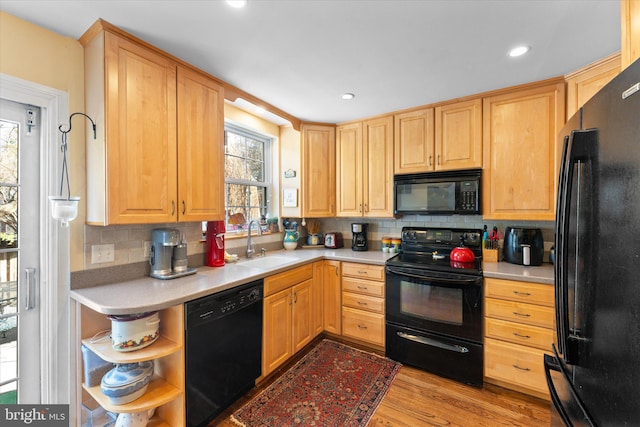 kitchen with black appliances, light countertops, and a sink