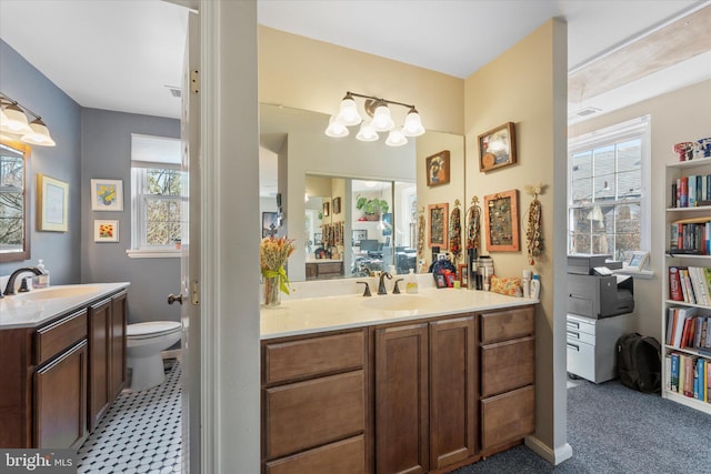 full bathroom featuring two vanities, a sink, and toilet