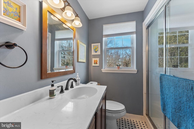 bathroom with toilet, a shower with shower door, vanity, baseboards, and tile patterned floors