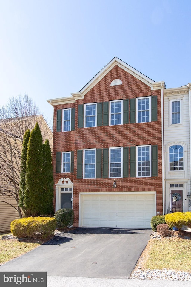 view of front of property featuring a garage, brick siding, and driveway