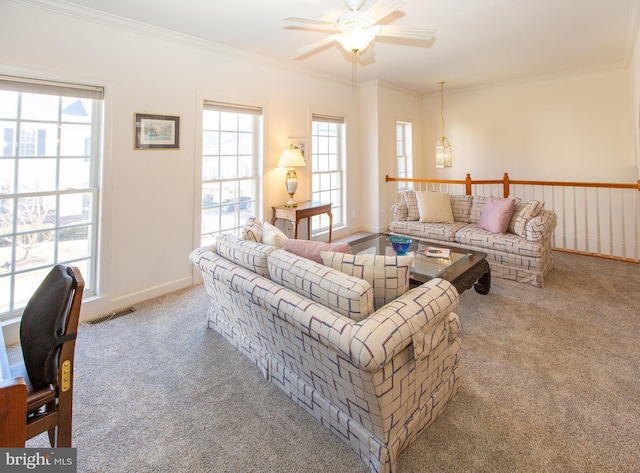 living room with visible vents, baseboards, ornamental molding, carpet flooring, and a ceiling fan