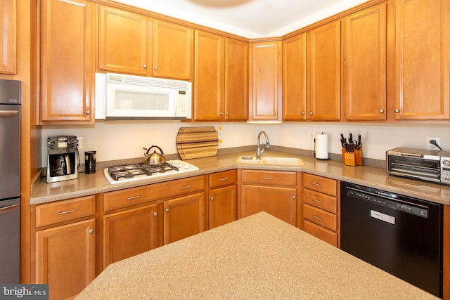 kitchen featuring a sink, white appliances, and light countertops