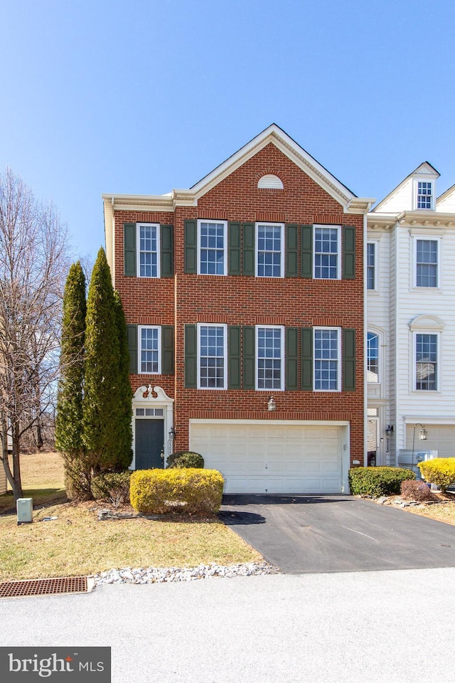 view of front of property featuring a garage, brick siding, and driveway