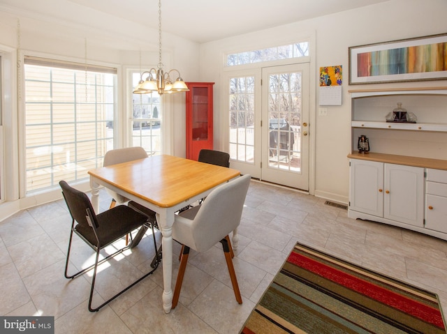 dining space with a notable chandelier, baseboards, and visible vents