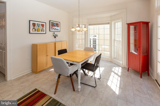 dining space with a notable chandelier and baseboards