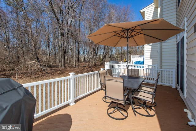 wooden deck with grilling area and outdoor dining area