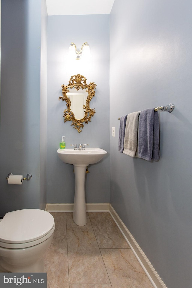 half bath with toilet and baseboards