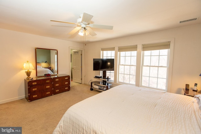 bedroom featuring visible vents, baseboards, light colored carpet, and a ceiling fan