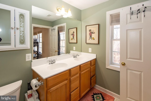 bathroom featuring plenty of natural light, visible vents, and a sink