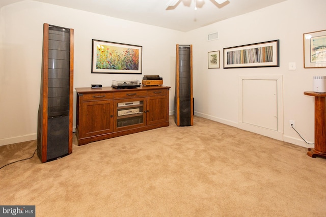 sitting room featuring light carpet, visible vents, baseboards, and a ceiling fan