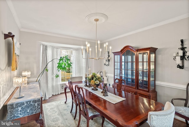 dining room featuring crown molding, wood finished floors, and a notable chandelier