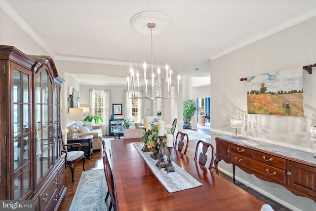 dining space with dark wood-style floors, crown molding, and a notable chandelier