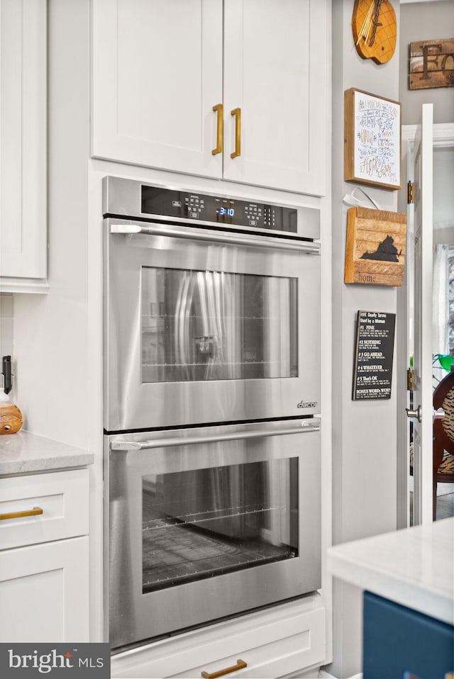 kitchen featuring double oven and white cabinets