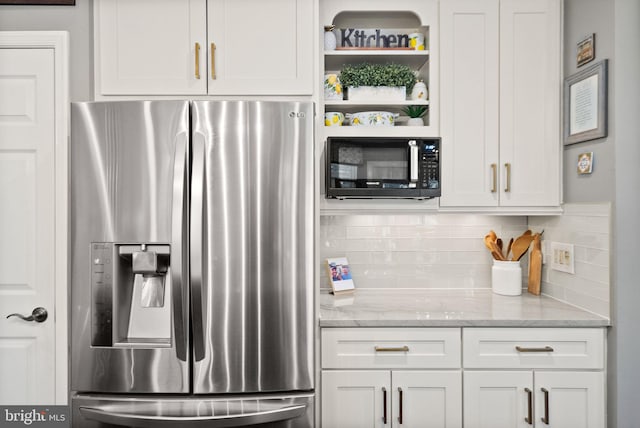 kitchen with white cabinetry, stainless steel fridge, black microwave, and decorative backsplash