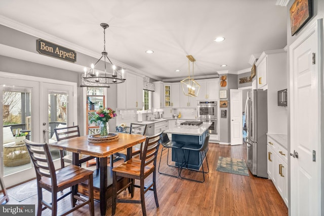 dining space featuring dark wood-style floors, a chandelier, and crown molding