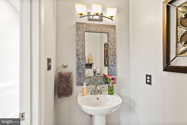 bathroom with tasteful backsplash and a sink