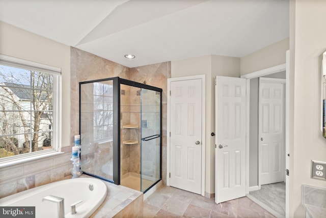 full bathroom featuring vaulted ceiling, a shower stall, and a bath