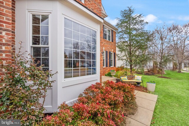 view of property exterior featuring brick siding and a lawn