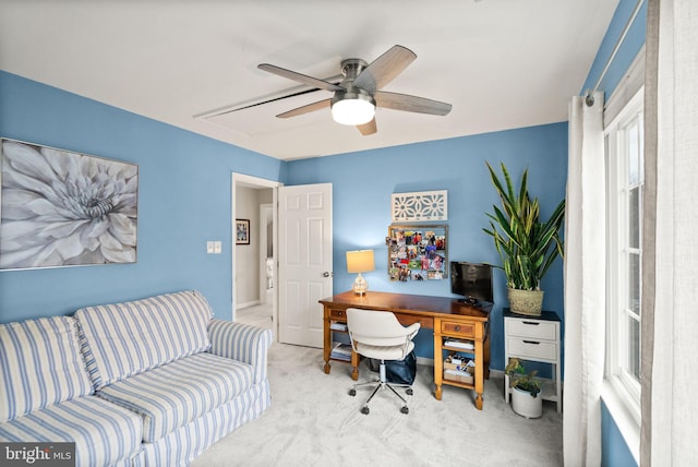 carpeted office space featuring a ceiling fan