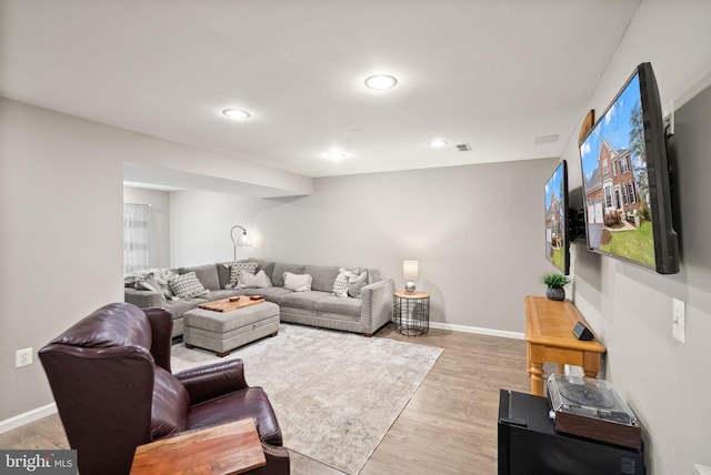 living room with visible vents, baseboards, wood finished floors, and recessed lighting