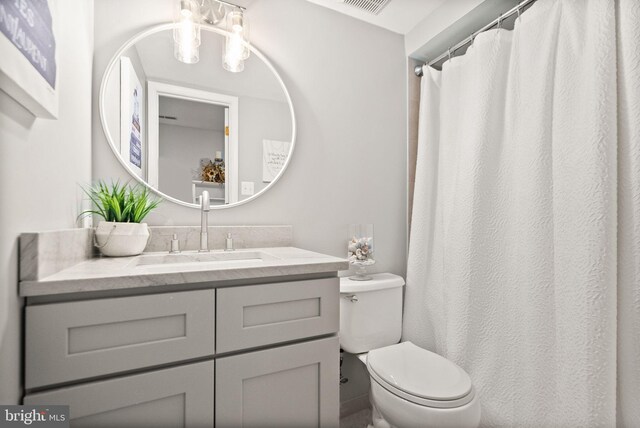 bathroom featuring visible vents, vanity, and toilet