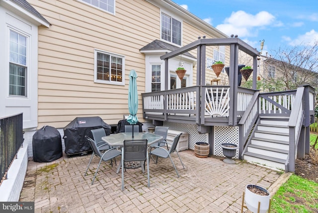 view of patio featuring a deck, stairway, outdoor dining area, and grilling area