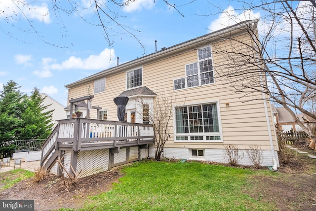 rear view of property with a deck and a yard