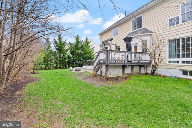 rear view of property featuring a yard, fence, and a wooden deck