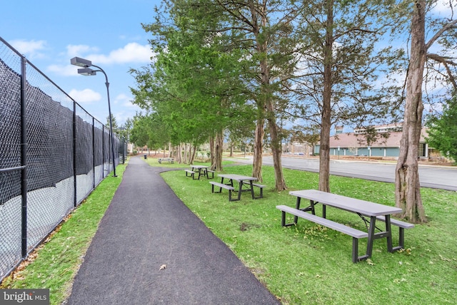 view of community with fence and a yard