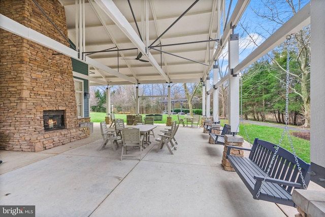 view of patio / terrace with outdoor dining area and an outdoor stone fireplace